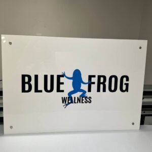 White Blue Frog Wellness logo sign with blue and black print and four corner standoffs.